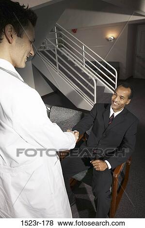 Stock Photo - meeting, multiethnic, men, smiling, patient, doctor, health. Fotosearch