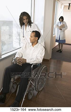 multiethnic, patient, doctor, wheelchair, health, pushing View Large Photo Image Picture - multiethnic, patient, doctor, wheelchair, health, pushing. Fotosearch