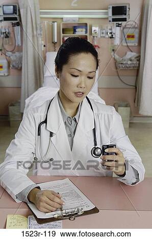 Stock Photo - woman, Asian, doctor, chart, health, checking, personnel. Fotosearch