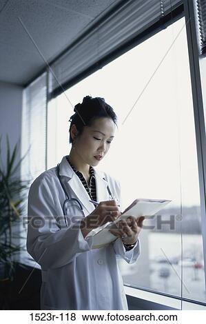 Stock Photo - woman, Asian, reading, doctor, chart, health, personnel. Fotosearch