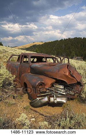 Stock Image - Abandoned car in a field at a ghost town, Comet, Butte Region, Montana, USA. Fotosearch