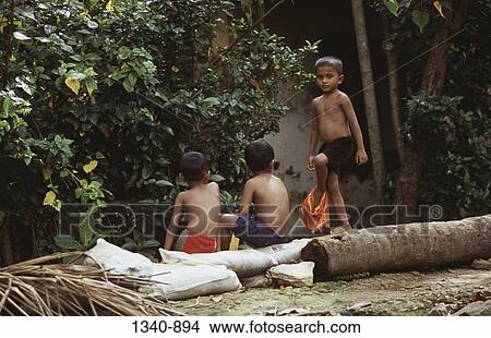 Boy walking on a log and his friends sitting on it, Kerala, India View Large Photo Image Picture - Boy walking on a log and his friends sitting on it, Kerala, India. Fotosearch