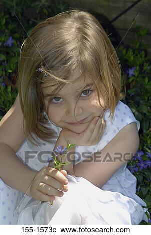 Close-up of a girl holding a plant View Large Photo Image Stock Image - Close-up of a girl holding a plant. Fotosearch