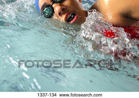 Close-up of a teenage girl swimming in a swimming pool View Large Photo Image Picture - Close-up of a teenage girl swimming in a swimming pool. Fotosearch