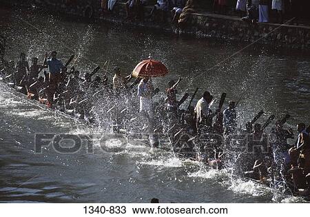 Stock Image - High angle view of a group of people participating in a traditional snake boat racing, Payippad Boat Race, Payippad Lake, Kerala, India. Fotosearch