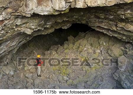 High angle view of a hiker standing at the entrance of a cave, Indian Well Cave, Lava Beds National Monument, California, USA View Large Photo Image Stock Image - High angle view of a hiker standing at the entrance of a cave, Indian Well Cave, Lava Beds National Monument, California, USA. Fotosearch