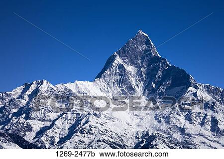 Stock Image - Low angle view of a mountain covered with snow, Mt Machhapuchhre, Pokhara, Nepal. Fotosearch