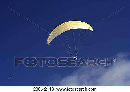 Low angle view of a person paragliding in the sky View Large Photo Image Stock Image - Low angle view of a person paragliding in the sky. Fotosearch