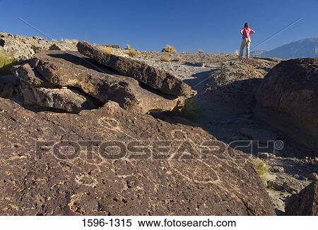 Petroglyph on a rock with a woman standing in the background, Fish Slough, Fish Slough Area of Critical Environmental Concern, Bishop, California, USA View Large Photo Image Stock Photography - Petroglyph on a rock with a woman standing in the background, Fish Slough, Fish Slough Area of Critical Environmental Concern, Bishop, California, USA. Fotosearch