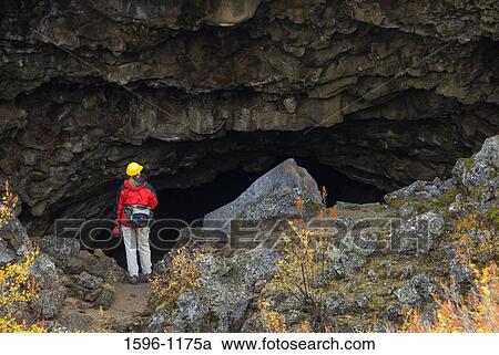 Rear view of a hiker standing at the entrance of a cave, Indian Well Cave, Lava Beds National Monument, California, USA View Large Photo Image Stock Image - Rear view of a hiker standing at the entrance of a cave, Indian Well Cave, Lava Beds National Monument, California, USA. Fotosearch