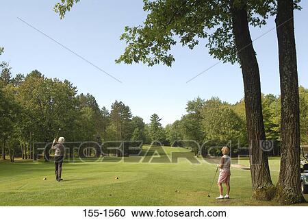 Rear view of a senior woman playing golf View Large Photo Image Stock Image - Rear view of a senior woman playing golf. Fotosearch