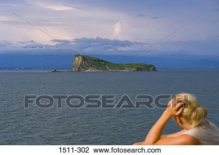 Rear view of a woman looking at an island in the sea, Costa Rica View Large Photo Image Stock Image - Rear view of a woman looking at an island in the sea, Costa Rica. Fotosearch