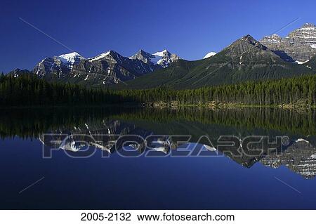 Stock Image - Reflection of mountains in water, Lake Herbert, Wenkchemna Peaks, Banff National Park, Alberta, Canada. Fotosearch