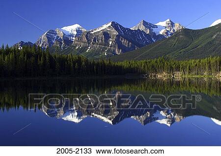 Reflection of mountains in water, Lake Herbert, Wenkchemna Peaks, Banff National Park, Alberta, Canada View Large Photo Image Stock Image - Reflection of mountains in water, Lake Herbert, Wenkchemna Peaks, Banff National Park, Alberta, Canada. Fotosearch