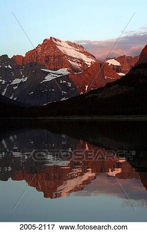 Reflection of mountains in water, Mount Gould, Swiftcurrent Lake, US Glacier National Park, Montana, USA View Large Photo Image Stock Photo - Reflection of mountains in water, Mount Gould, Swiftcurrent Lake, US Glacier National Park, Montana, USA. Fotosearch