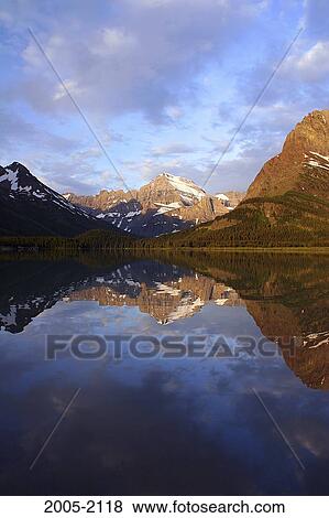 Reflection of mountains in water, Mount Gould, Swiftcurrent Lake, US Glacier National Park, Montana, USA View Large Photo Image Stock Photo - Reflection of mountains in water, Mount Gould, Swiftcurrent Lake, US Glacier National Park, Montana, USA. Fotosearch