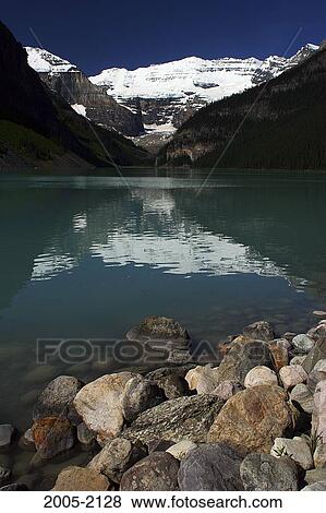 Stock Photo - Reflection of snowcapped mountains in water, Lake Louise, Victoria Glacier, Banff National Park, Alberta, Canada. Fotosearch