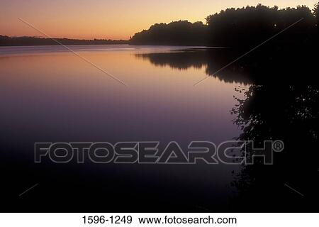 Stock Photo - Reflection of trees in water at sunrise, Batterson Park Pond, Batterson Park, New Britain, Connecticut, USA. Fotosearch