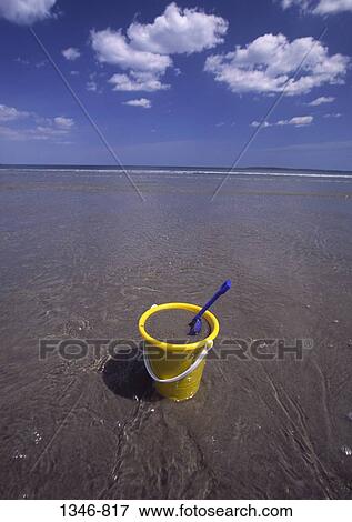 Stock Photo - Sand pail and a shovel on the beach. Fotosearch