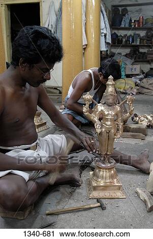Stock Image - Sculptors making a bronze sculpture of a Hindu god, Swamimalai, Thanjavur District, Tamil Nadu, India. Fotosearch