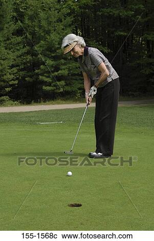 Stock Image - Side profile of a senior woman playing golf. Fotosearch