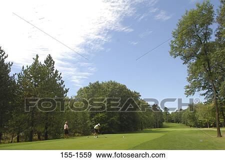 Side profile of two men playing golf View Large Photo Image Stock Photo - Side profile of two men playing golf. Fotosearch