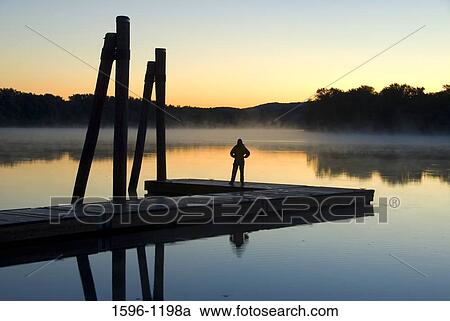 Silhouette of a person standing on a pier at dawn, Connecticut River, Ferry Park, Rocky Hill, Connecticut, USA View Large Photo Image Stock Image - Silhouette of a person standing on a pier at dawn, Connecticut River, Ferry Park, Rocky Hill, Connecticut, USA. Fotosearch