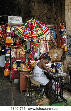 Tailor stitching umbrellas used for decorating the temple chariot, Sri Meenakshi Hindu Temple, Madurai, Tamil Nadu, India View Large Photo Image Stock Photography - Tailor stitching umbrellas used for decorating the temple chariot, Sri Meenakshi Hindu Temple, Madurai, Tamil Nadu, India. Fotosearch