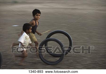 Two boys playing with tires, Tamil Nadu, India View Large Photo Image Stock Image - Two boys playing with tires, Tamil Nadu, India. Fotosearch
