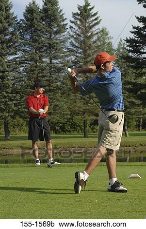 Stock Image - Two men playing golf. Fotosearch