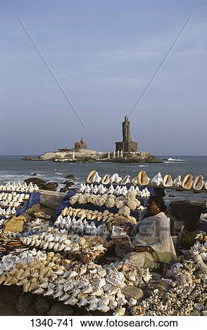 Woman selling sea shells on the beach with a statue and a memorial in the background, Vivekananda Rock Memorial, Kanyakumari, Tamil Nadu, India View Large Photo Image Stock Image - Woman selling sea shells on the beach with a statue and a memorial in the background, Vivekananda Rock Memorial, Kanyakumari, Tamil Nadu, India. Fotosearch