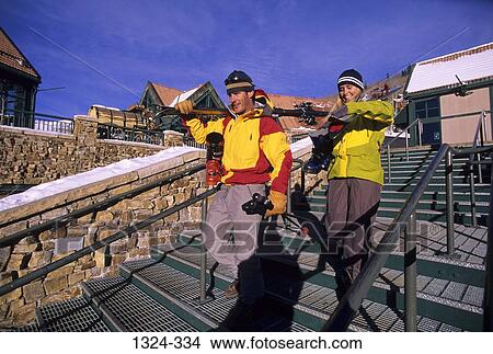 Young couple holding skis and descending steps, Mountain Village, Telluride, Colorado, USA View Large Photo Image Picture - Young couple holding skis and descending steps, Mountain Village, Telluride, Colorado, USA. Fotosearch