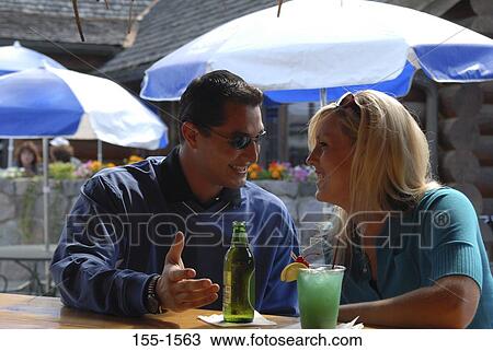 Young couple sitting in a restaurant View Large Photo Image Stock Image - Young couple sitting in a restaurant. Fotosearch