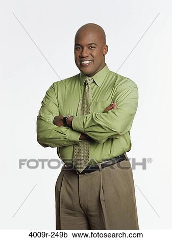 Stock Image - Businessman standing with his arms crossed and smiling. Fotosearch
