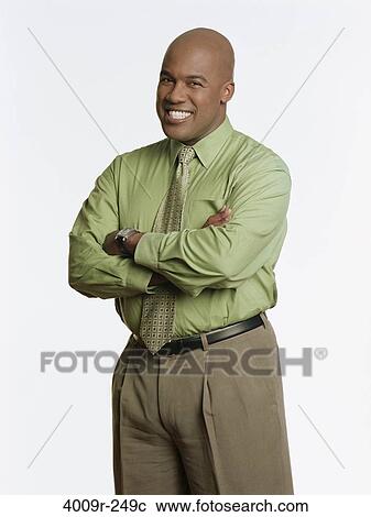 Stock Image - Businessman standing with his arms crossed and smiling. Fotosearch