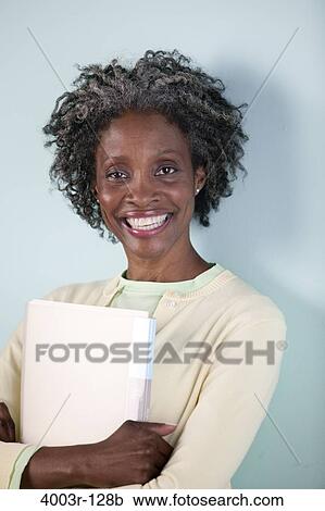 Businesswoman holding a file and smiling View Large Photo Image Stock Image - Businesswoman holding a file and smiling. Fotosearch