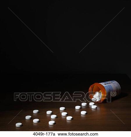 Close-up of pills spilling out of a bottle View Large Photo Image Stock Image - Close-up of pills spilling out of a bottle. Fotosearch