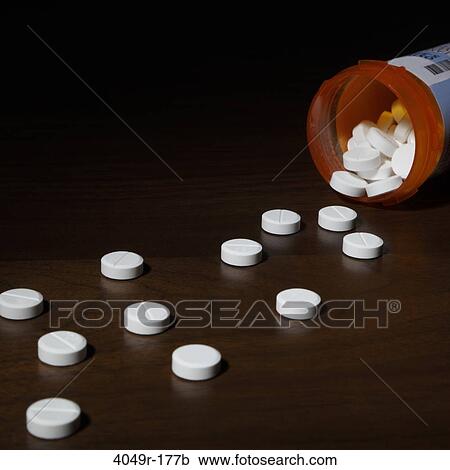 Close-up of pills spilling out of a bottle View Large Photo Image Stock Image - Close-up of pills spilling out of a bottle. Fotosearch