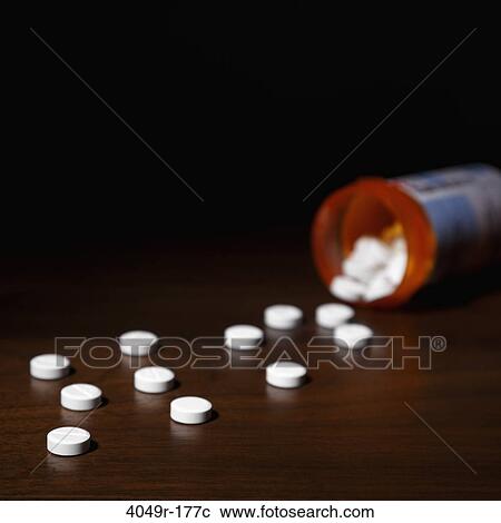 Close-up of pills spilling out of a bottle View Large Photo Image Stock Image - Close-up of pills spilling out of a bottle. Fotosearch