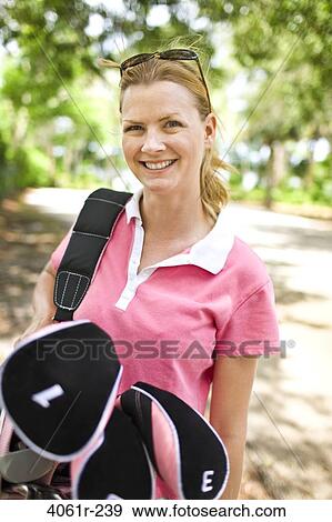 Mid adult woman carrying a golf bag View Large Photo Image Stock Photo - Mid adult woman carrying a golf bag. Fotosearch