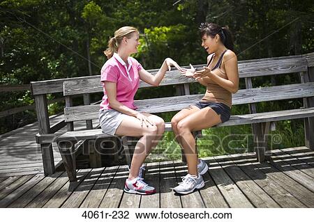 Mid adult woman showing her diamond ring to her friend View Large Photo Image Stock Image - Mid adult woman showing her diamond ring to her friend. Fotosearch