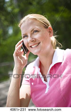 Mid adult woman talking on a mobile phone View Large Photo Image Stock Image - Mid adult woman talking on a mobile phone. Fotosearch