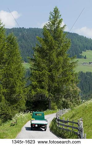 Stock Image - Pick-up truck moving on the road, Santa Maddalena, Funes Valley, Dolomites, Trentino-Alto-Adige, Italy. Fotosearch