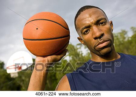 Portrait of a young man holding a basketball View Large Photo Image Picture - Portrait of a young man holding a basketball. Fotosearch