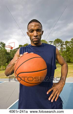 Portrait of a young man holding a basketball View Large Photo Image Stock Image - Portrait of a young man holding a basketball. Fotosearch