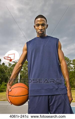 Portrait of a young man holding a basketball View Large Photo Image Stock Image - Portrait of a young man holding a basketball. Fotosearch