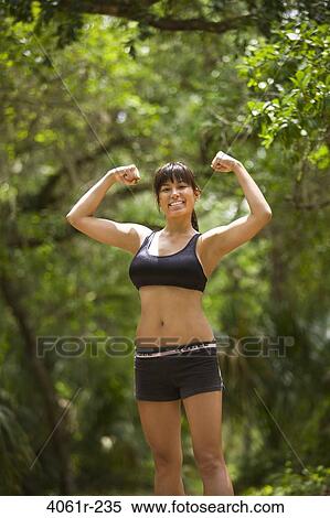 Portrait of a young woman flexing her muscles View Large Photo Image Stock Photography - Portrait of a young woman flexing her muscles. Fotosearch