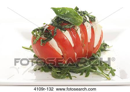 Stock Image - Tomato stuffed with mozzarella slices. Fotosearch