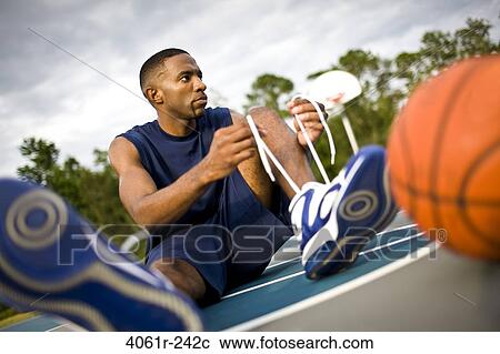Young man tying his shoelaces View Large Photo Image Stock Image - Young man tying his shoelaces. Fotosearch