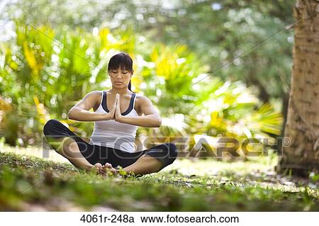 Young woman practicing yoga in a park View Large Photo Image Stock Image - Young woman practicing yoga in a park. Fotosearch